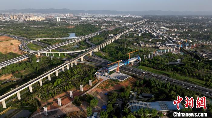 航拍正在建設(shè)的跨越成都繞城高速公路連續(xù)梁施工現(xiàn)場(chǎng)，旁邊依次為已運(yùn)營(yíng)的成渝高速鐵路和機(jī)場(chǎng)高速公路?！⒅铱?攝