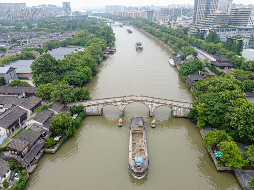 5月27日，一艘貨船駛過京杭大運(yùn)河南端標(biāo)志建筑杭州拱宸橋。(無人機(jī)照片)新華社記者江漢 攝