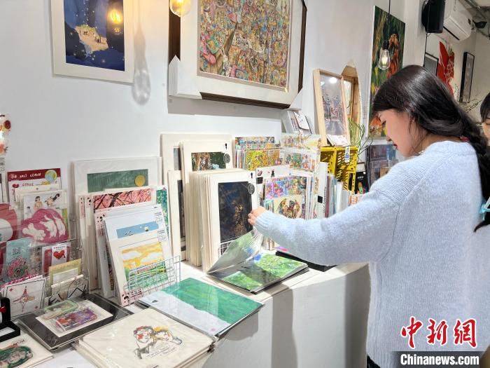 圖為藝術品商店內，顧客挑選插畫作品?！＄婌?攝