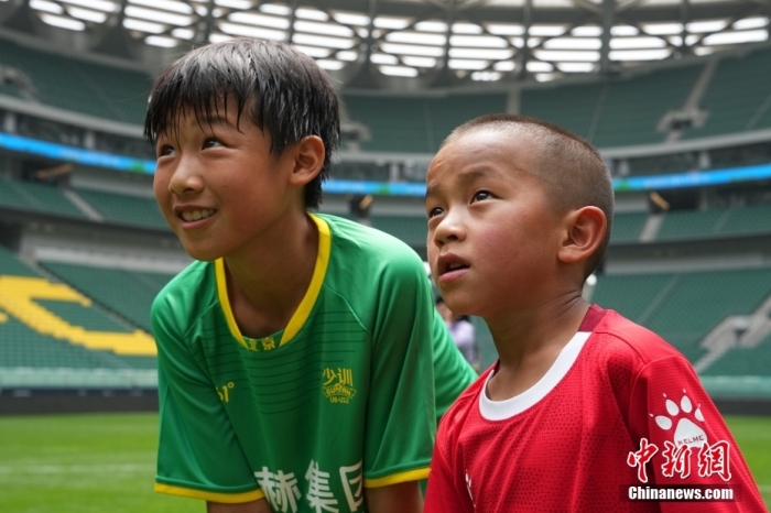 圖為北京國安小球員陳小北和7歲的俄金仁增在一起觀看場內(nèi)播放的紀(jì)錄片。<a target='_blank' href='/' _fcksavedurl='/'><p  align=