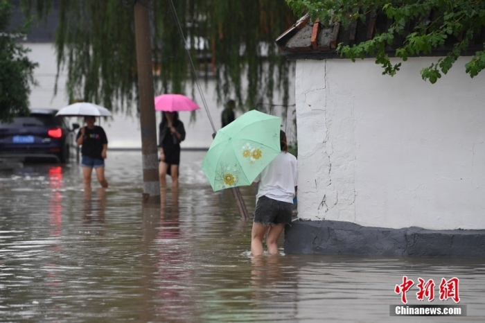 7月31日，市民行走在雨中的北京房山區(qū)瓦窯頭村。北京市氣象臺當日10時發(fā)布分區(qū)域暴雨紅色預警信號。北京市水文總站發(fā)布洪水紅色預警，預計當日12時至14時，房山區(qū)大石河流域?qū)⒊霈F(xiàn)紅色預警標準洪水。<a target='_blank' href='/'><p  align=