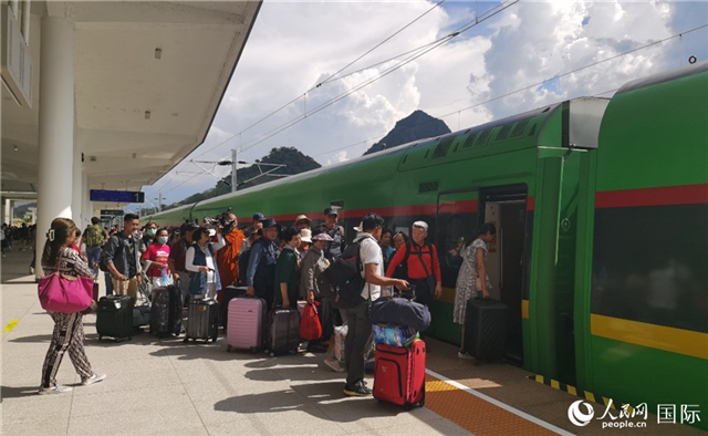 乘坐中老鐵路國際旅客列車的旅客在老撾瑯勃拉邦站排隊上車。人民網(wǎng)記者 杜明明攝