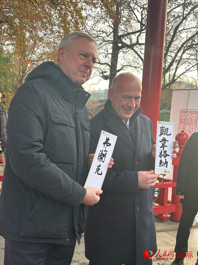 柏林市長韋格納（右）、動物園監(jiān)事會主席布魯克曼（左）手持中國文化中心工作人員現(xiàn)場手書的中文名字。人民網(wǎng)記者 徐馨攝