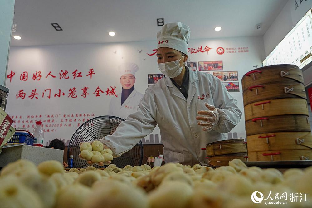 3月31日，在浙江省嵊州市甘霖鎮(zhèn)，嵊州小吃從業(yè)者沈紅平把蒸熟的小籠包晾涼，打包冷藏售賣。人民網(wǎng) 章勇濤攝