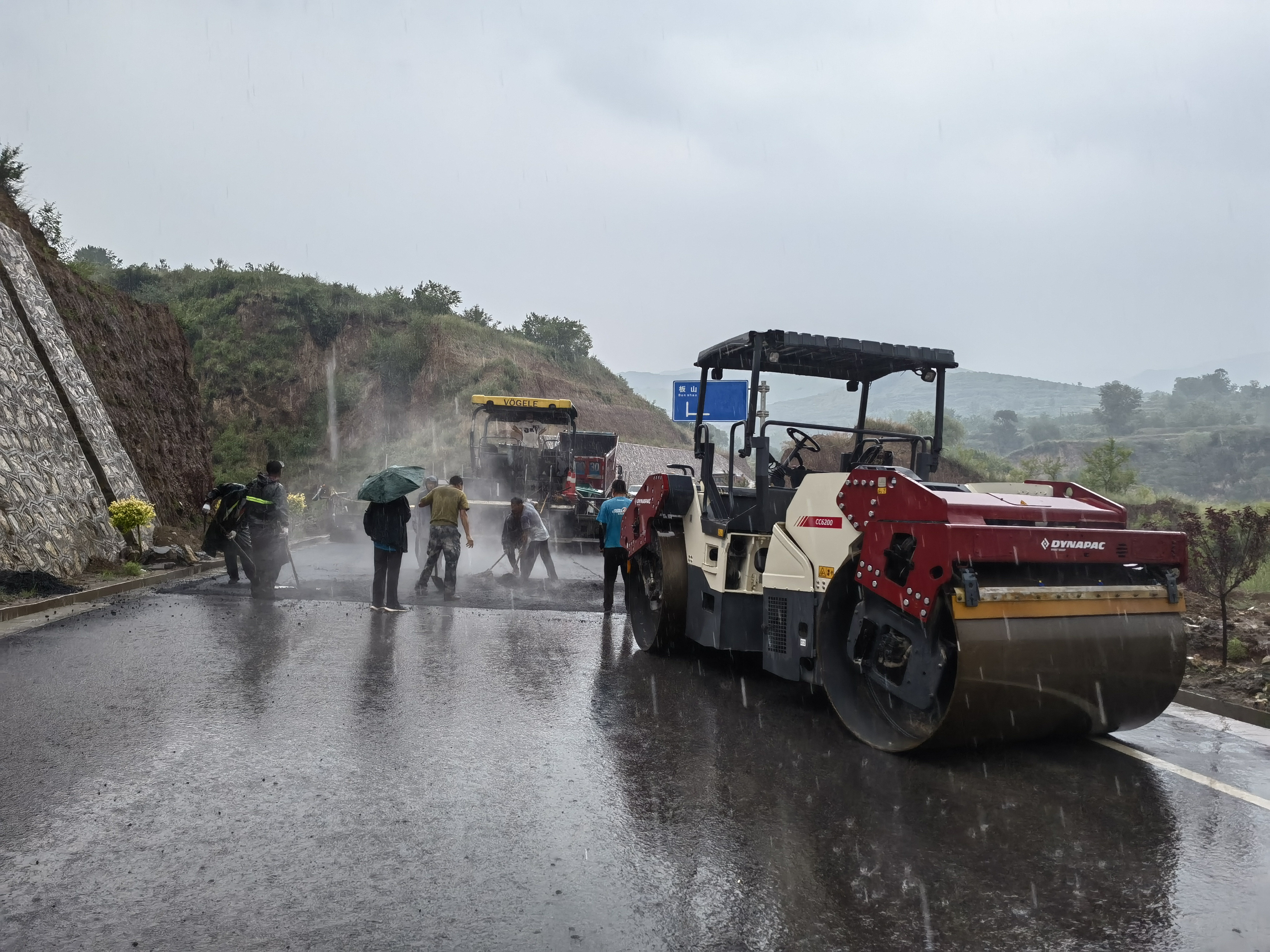 路橋工人在大雨中搶修道路。李華英 攝