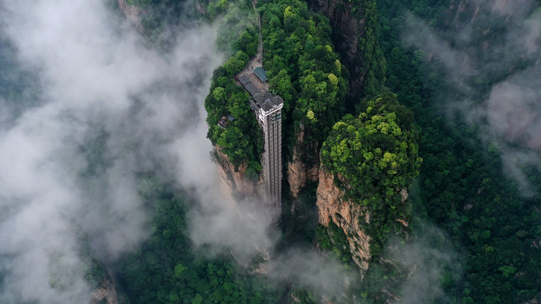 位于張家界武陵源景區(qū)的百龍?zhí)焯蓁偳对谠旗F繚繞的峰林間，雄偉壯觀。吳勇兵攝