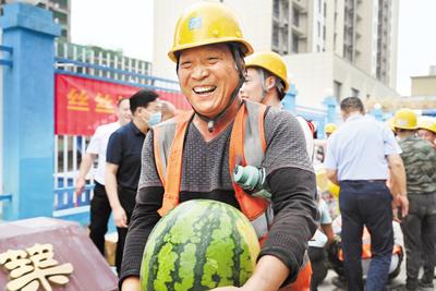 近日，石家莊市橋西區(qū)總工會到中建四局河北分公司某項目工地為一線職工發(fā)放防暑慰問品。圖為領到防暑慰問品的建筑工人露出開心的笑容。 省總工會供圖