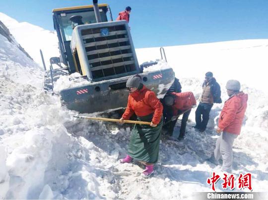 圖為普布卓瑪(左一)與養(yǎng)護工人一起抗擊雪災，搶險保通?！“⒗锏貐^(qū)公路養(yǎng)護段供圖 攝