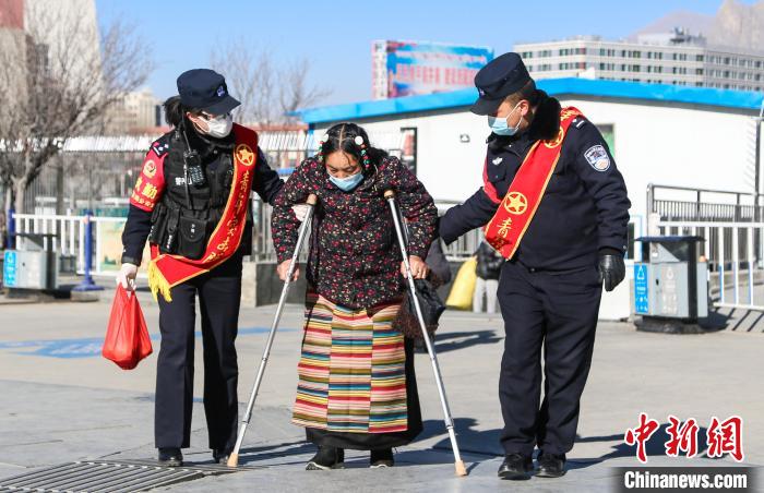 圖為拉薩鐵路公安民警幫助老人進(jìn)站乘車。　胡安鵬 攝