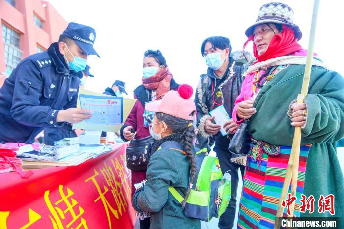 圖為拉薩鐵路公安民警向旅客發(fā)放乘車安全宣傳資料。　黃飛 攝