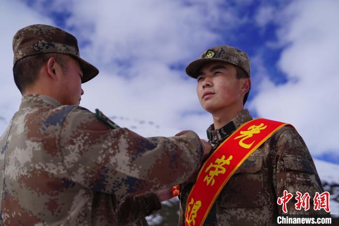 排長王朝偉(圖左)給退伍老兵佩戴大紅花?！∥鞑厣侥宪姺謪^(qū)某團(tuán)供圖