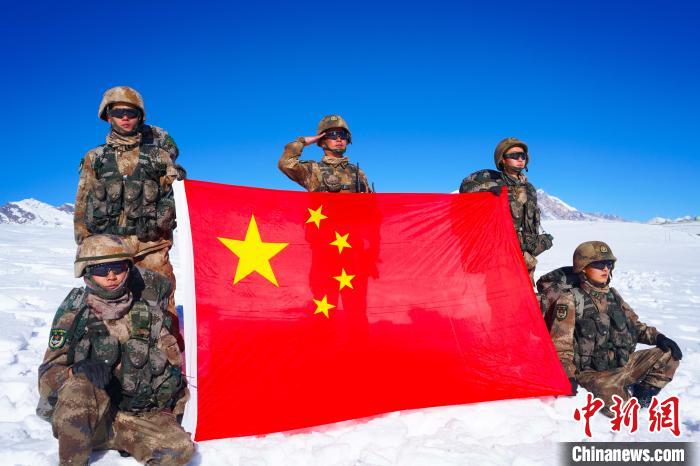 官兵在山頂與國旗合影。　西藏山南軍分區(qū)某團供圖