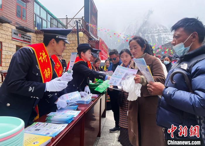 圖為山南玉麥邊境派出所民警為轄區(qū)群眾發(fā)放法律知識(shí)宣傳單?！＄婗?　攝