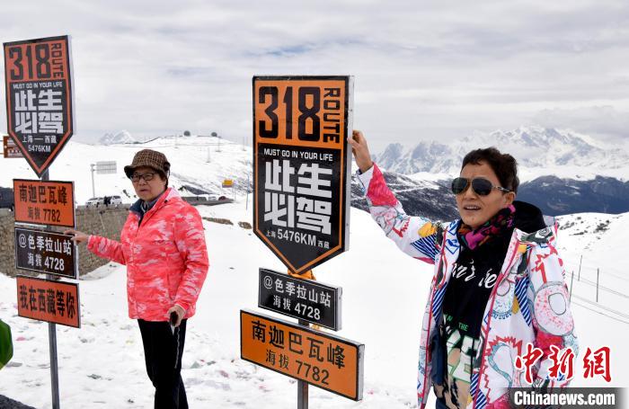 圖為5月14日，西藏林芝色季拉山觀景臺(tái)，游客與南迦巴瓦峰合影?！±盍?攝