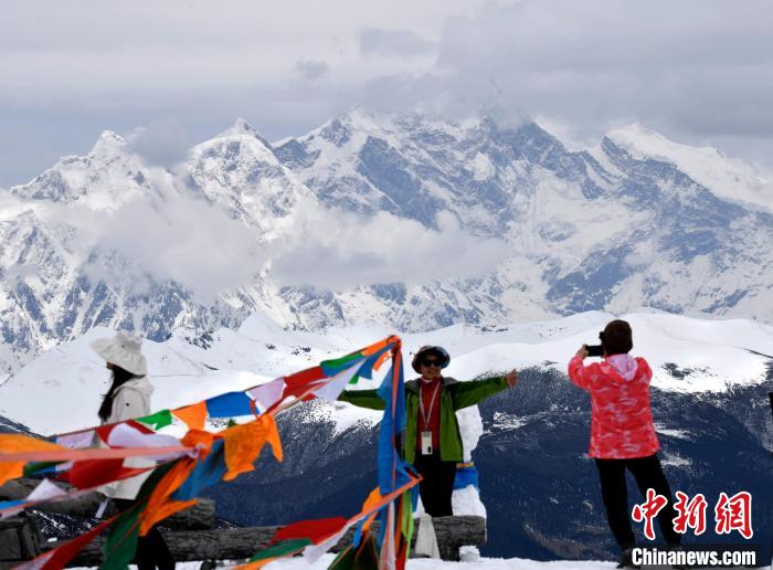 圖為5月14日，西藏林芝色季拉山觀景臺(tái)，游客與南迦巴瓦峰合影?！±盍?攝