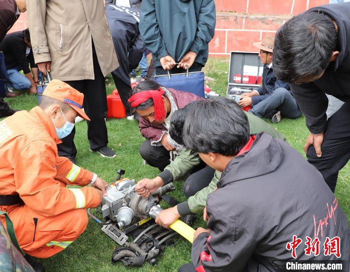 圖為森林消防員為護(hù)林員講解滅火裝備的使用方法。　昌都市森林消防支隊 供圖