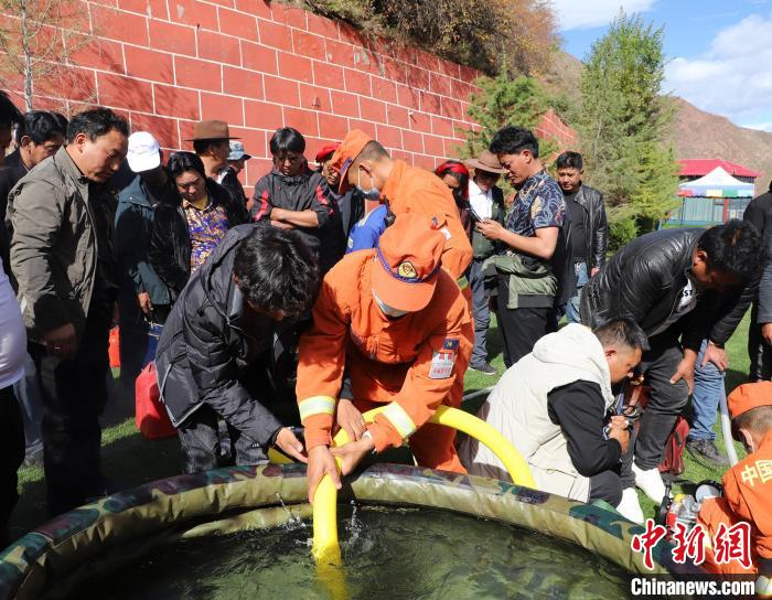 圖為森林消防員為護(hù)林員講解滅火裝備的使用方法。　昌都市森林消防支隊 供圖