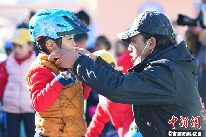 圖為拉薩市實(shí)驗(yàn)幼兒園孩子在教練的幫助下穿戴頭盔。　何蓬磊 攝