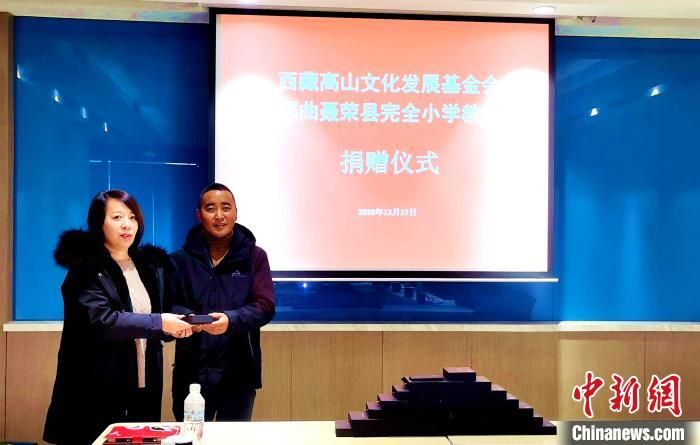 圖為西藏高山文化發(fā)展基金會(huì)理事長溫麗向聶榮縣完全小學(xué)負(fù)責(zé)人捐助儀器。　于賓 攝