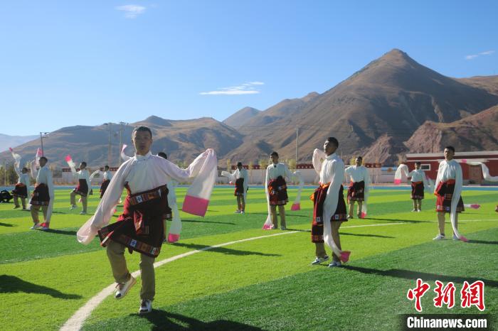 圖為青海師范大學(xué)附屬玉樹實(shí)驗(yàn)學(xué)校學(xué)生在綠茵場(chǎng)跳起囊謙古舞—卓根瑪。　程雨 攝