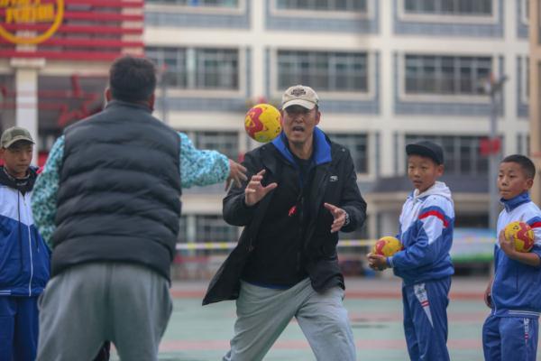 在高原上教孩子們打手球，“慢慢兒來，甭著急！”