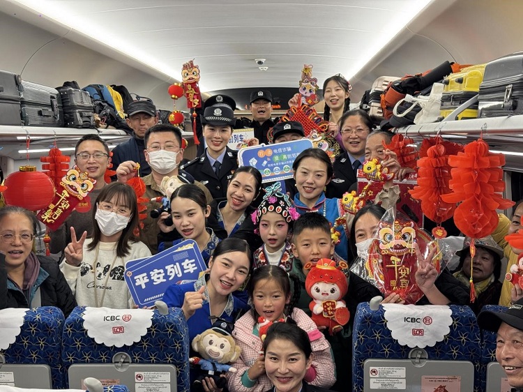 春節(jié)期間，在中老鐵路磨萬（磨丁—萬象）段，鐵路客運員工與乘客合影留念。李加勇攝