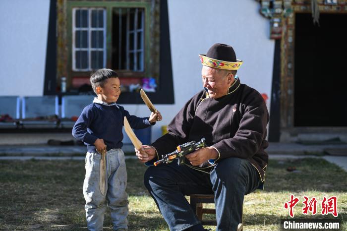 圖為米林縣扎西繞登鄉(xiāng)彩門村64歲的洛桑帶著孫子巴桑在院子的草地上玩耍?！『闻罾?攝