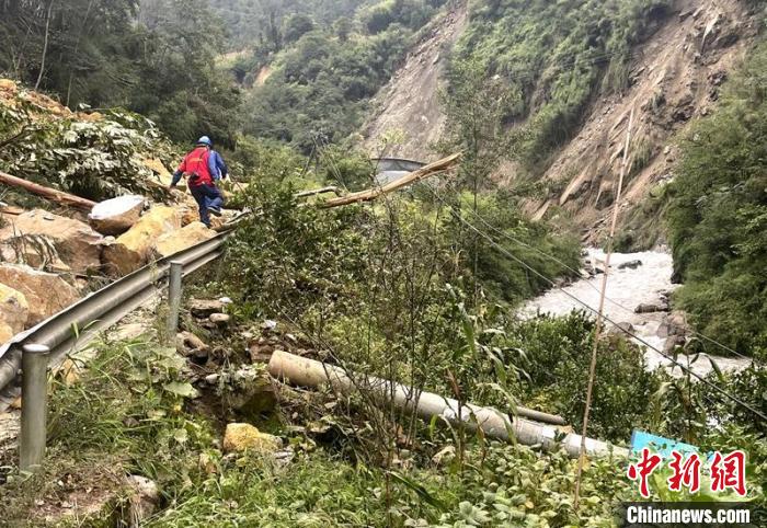 電力搶險人員快速通過危險路段，旁邊是受損的電力線路 四川電力供圖