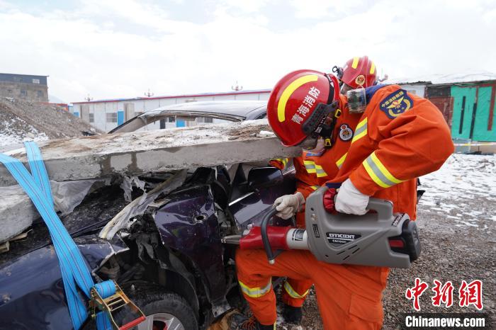 圖為地震實戰(zhàn)拉動現(xiàn)場，參演人員進(jìn)行車輛破拆。　玉樹消防供圖