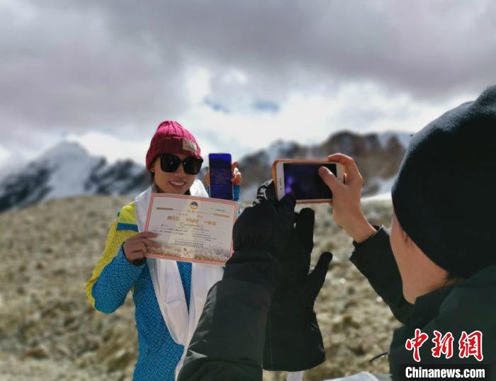 圖為5日，登頂洛堆峰的登山者獲得西藏自治區(qū)登山協(xié)會頒發(fā)的登頂證明?！垈?攝