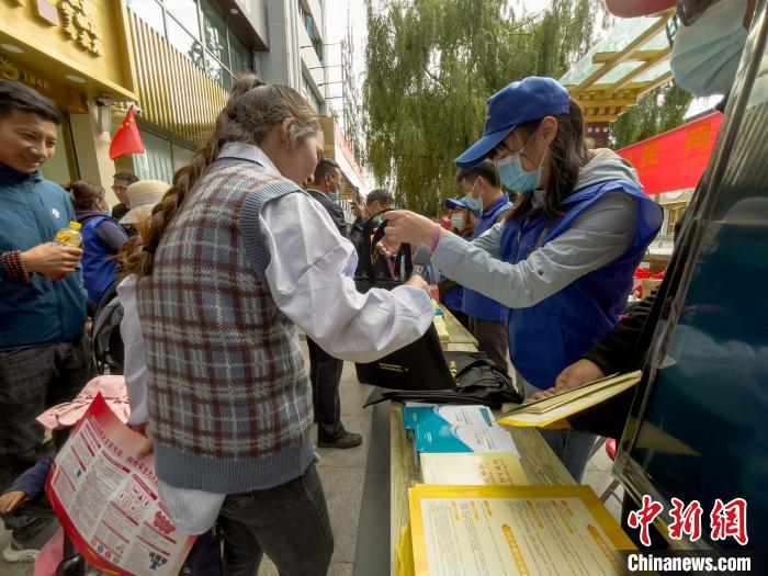 圖為志愿者為市民發(fā)放網(wǎng)絡安全宣傳手冊?！≈x牧 攝