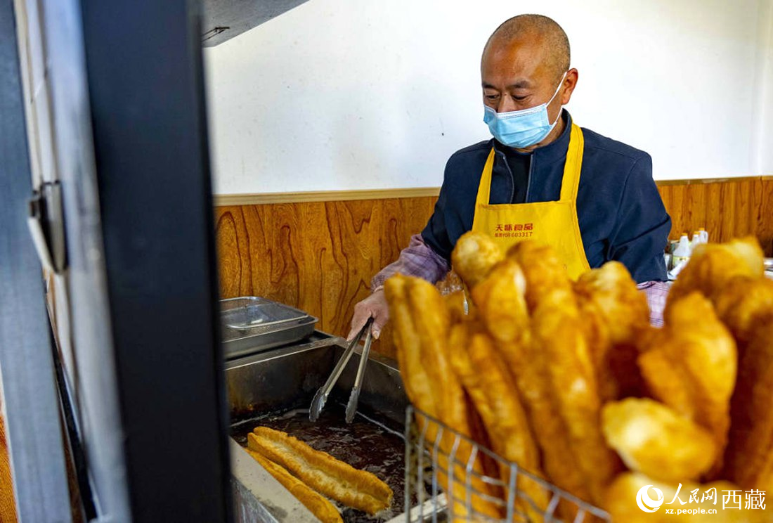 早餐店老板正在炸油條。人民網(wǎng) 次仁羅布攝