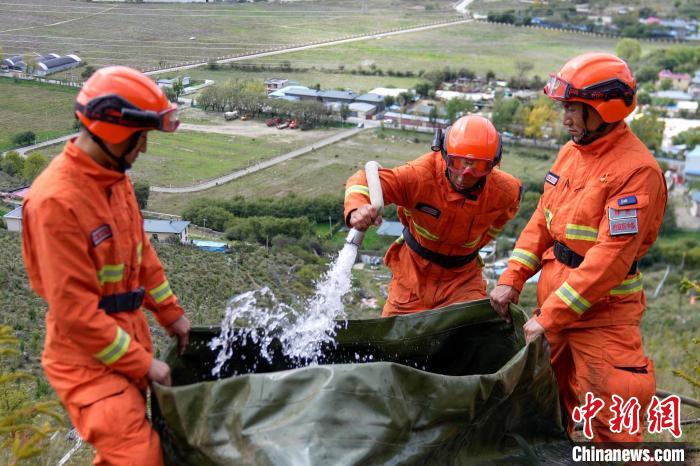 技能大練兵過程中，消防員在陡坡上向蓄水池注水?！±顕鵂c 攝