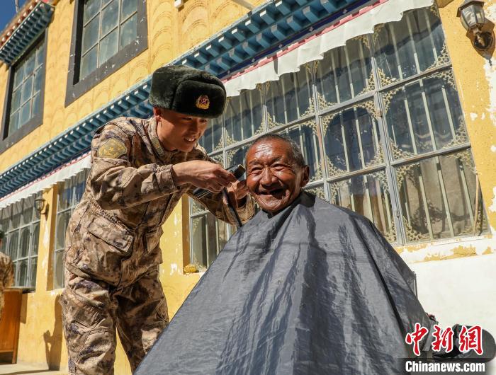 圖為阿里軍分區(qū)某邊防團官兵為駐地群眾理發(fā)迎藏歷新年?！〉┰鰝愔?攝