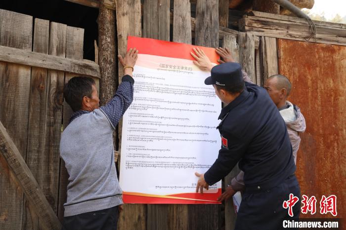 圖為亞東邊檢站民警與駐地邊民群眾共同張貼國(guó)家安全知識(shí)教育海報(bào)?！問|邊檢站 供圖