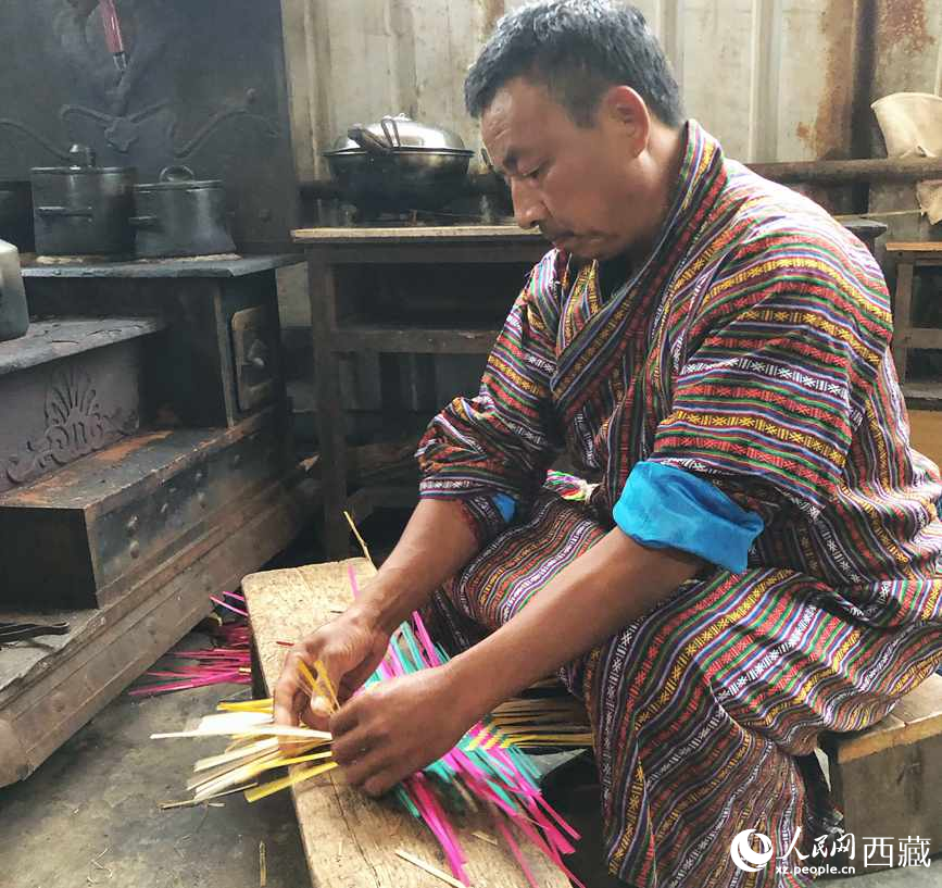 門巴族漢子愛明正在編織藤竹品。