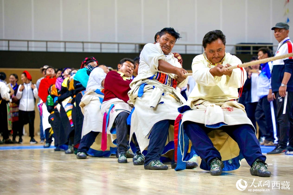 身著民族服裝的農(nóng)牧民選手在拔河比賽現(xiàn)場。