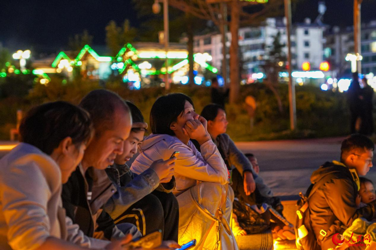 市民坐在西藏林芝市民族團結(jié)廣場臺階上欣賞音樂噴泉。人民網(wǎng)記者 趙晨攝