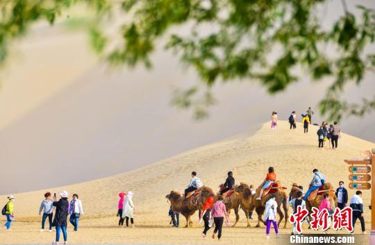 甘肅敦煌開啟旅游旺季數(shù)萬(wàn)人“五一”暢游鳴沙山